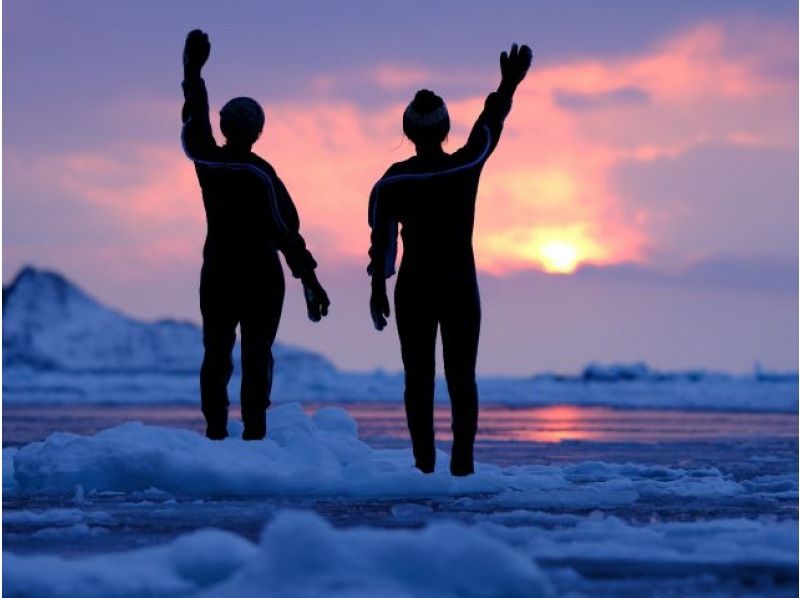 Time-lapse video of a Kamakura being built in 4K cinematic quality, followed by an interior shot of a traveler sleeping soundly inside, warm and cozy, culminating in a breathtaking time-lapse sunrise over the snow-covered Hokkaido landscape shot with a drone