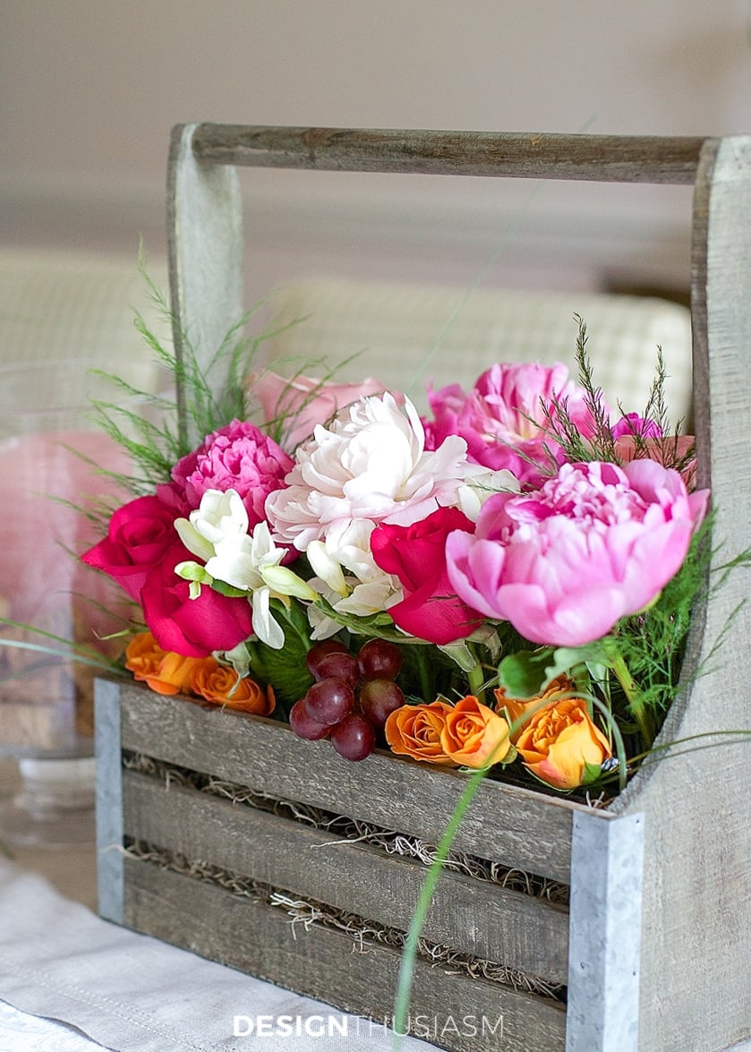 Close-up of hands arranging freshly cut flowers in a vase