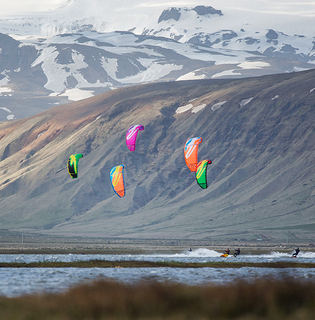 A snowkiter silhouetted against a dramatic Icelandic sunset, capturing the vastness and solitude of the landscape.
