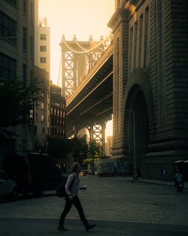 A view of the hostel's communal kitchen, showing travelers swapping stories over instant noodles. It has exposed brick and metal accents, with minimalist design.