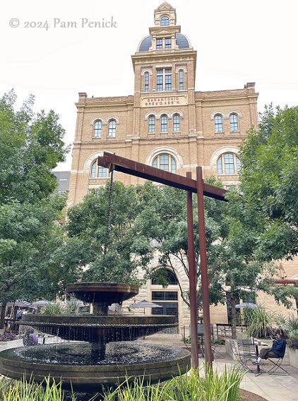 Marcus Bell, an architect from Chicago, sitting in Hotel Emma's Sternewirth bar, raises a La Babia Margarita. The dramatic neon lighting captures the blurred crowd behind him.