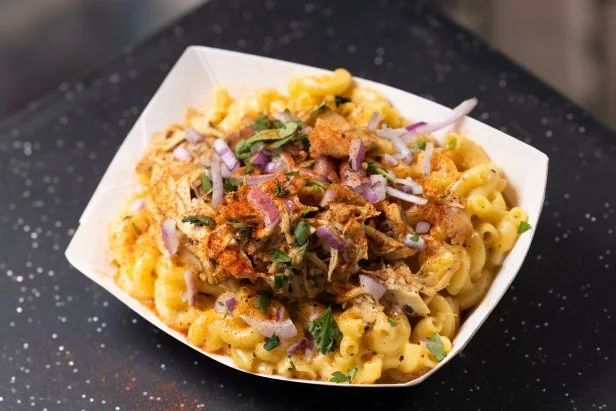 A vibrant shot of a scoop of Strawberry Honey Balsamic with Black Pepper ice cream from Salt & Straw, highlighting its unique color and texture. The image emphasizes that it is a Portland-exclusive flavor and a must-try dessert for foodies.