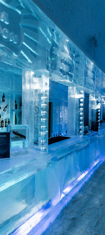 Experiment with different angles and perspectives to capture the intricate details of the ice carvings, focusing on patterns and textures.