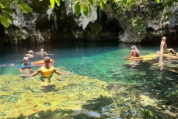 Sunset over Sunset Beach in Oahu, Hawaii. People are sitting on the sand, enjoying the sunset.