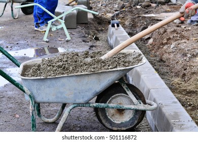 Hands mixing soil block ingredients in a rustic wheelbarrow