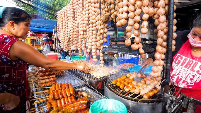 A wide shot captures the vibrant energy of a bustling Bangkok night market