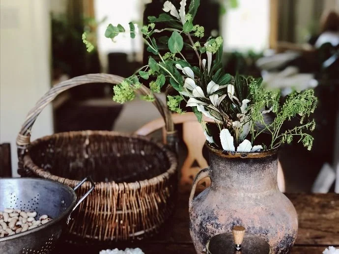 Greenery being attached to a log using twine.
