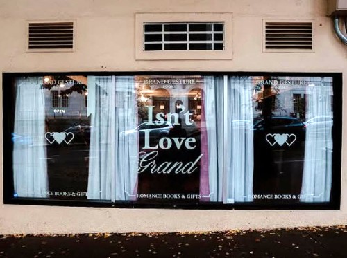 An author event at The Book Nook, featuring a local author signing books for an enthusiastic crowd, candid shot, warm and inviting atmosphere, diverse group of people.
