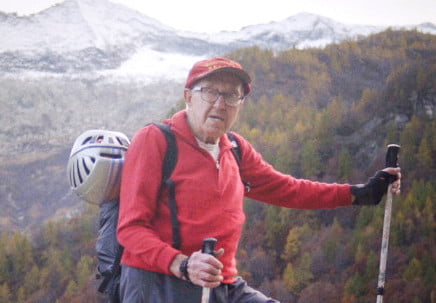 A climber on a mountainside with the sky in the background
