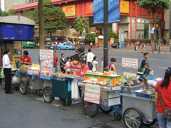 A sizzling wok prepares Pad Thai, showcasing the glistening noodles and colorful toppings