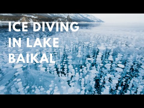 A dramatic wide shot showcasing all three activities in miniature—a tiny kite surfer against an Icelandic glacier, a diver emerging from Lake Baikal, and a skijorer silhouetted against a Montana sunset.