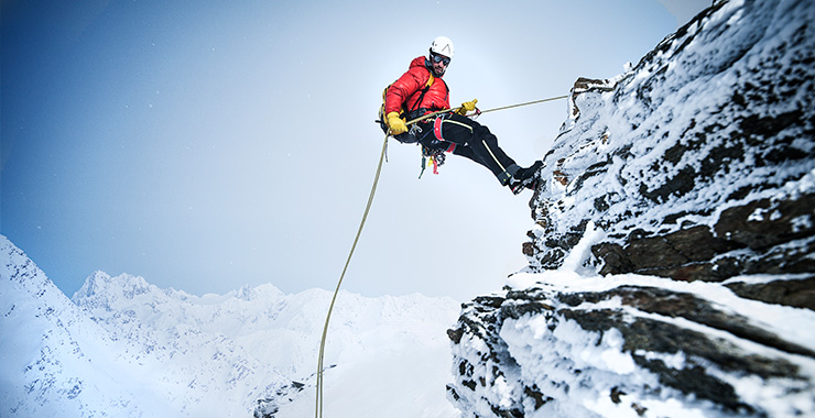 A snowmobiler races through a snowy forest, kicking up a cloud of powder. The image showcases the speed, agility, and excitement of snowmobiling, perfect for evoking a sense of adventure.