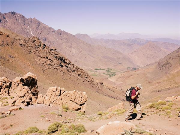 A bustling marketplace in Chefchaouen, showcasing local products and vendors, with the city's iconic blue buildings in the background.