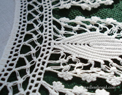Close-up of a white linen doily, highlighting the delicate crochet edge.