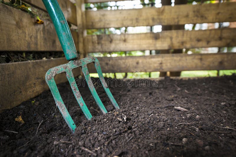 hands using compost tumbler garden setting