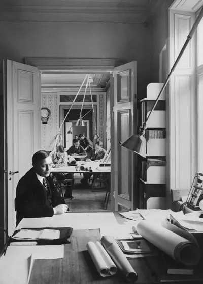 Ett Hem's library with a fireplace, comfortable armchairs, and bookshelves