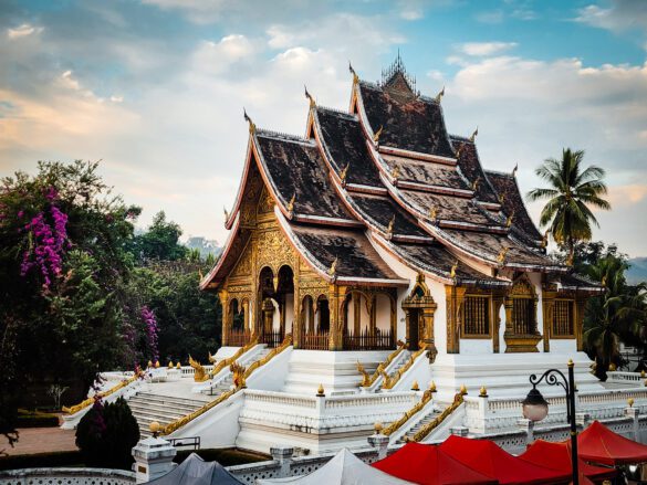 A stunning view of Luang Prabang with the Mekong River at sunset, showing the golden hour and temples in the background.