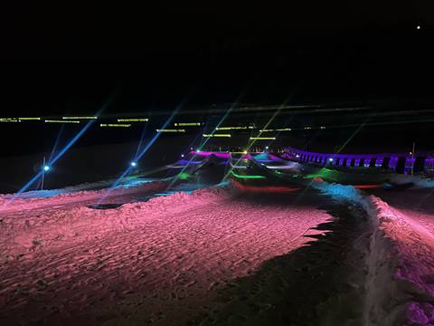 Snow tuber illuminated by LED lights against a starry night sky in Park City, Utah - capturing speed and excitement