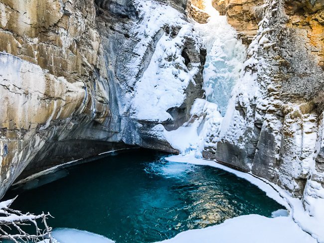 A cozy suite at the Buffalo Mountain Lodge featuring a wood-burning fireplace and large windows offering panoramic mountain views, illustrating the warm and inviting atmosphere of the lodge.