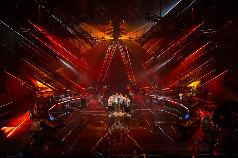 A split-screen image showing two groups of fans: one cheering enthusiastically, the other arguing intensely, representing the divided reaction to Player X's ban. The alt text describes the conflicting emotions and opinions within the CS2 community regarding the situation.