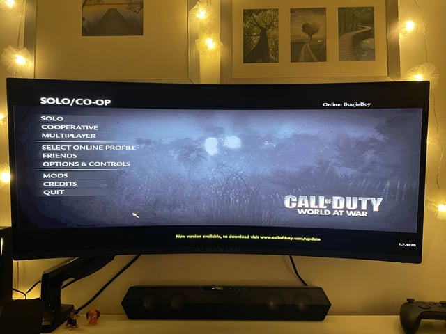 Action shot of two people playing Overcooked! 2 on the portable monitor with the SFF PC connected. The scene should be lit warmly and convey a sense of fun and camaraderie.