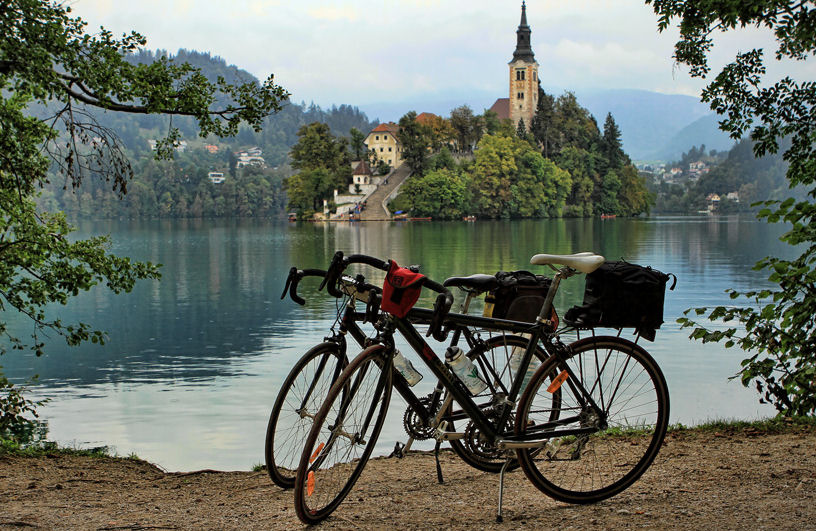 A person riding a Bicikelj bike through the streets of Ljubljana, with the city skyline in the background