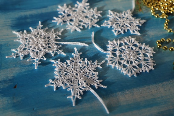 A very close-up shot showcasing the delicate details of a paper snowflake, highlighting the clean and precise cuts achieved with the Fiskars scissors, emphasizing the intricate craftsmanship.