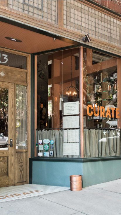 A vibrant and bustling restaurant scene in Asheville, with outdoor seating and lively energy.