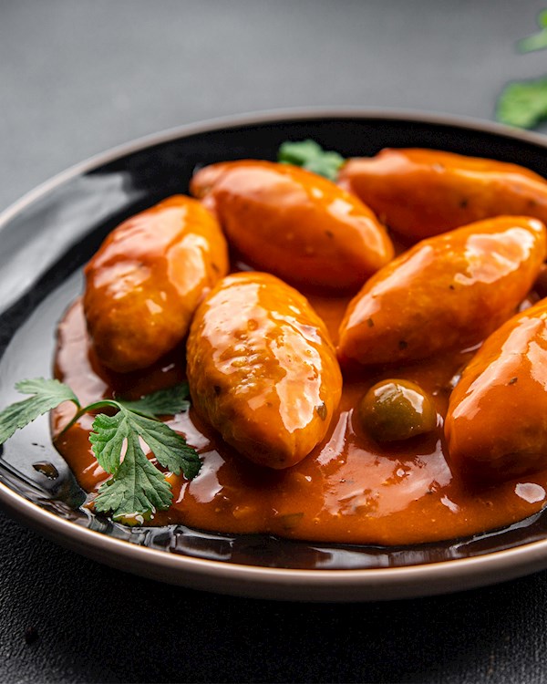 Close-up of a chef preparing quenelles in a traditional bouchon kitchen.