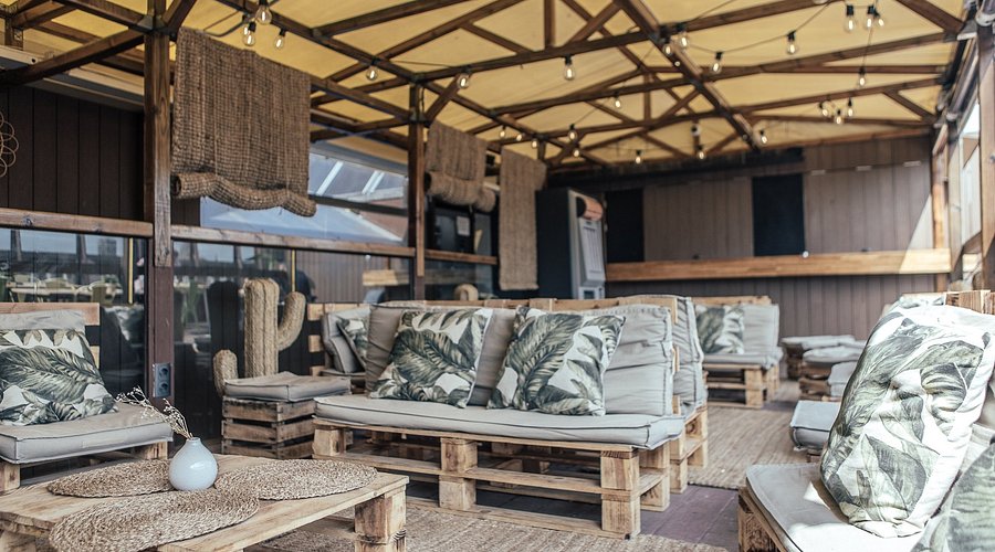 Interior shot of Generator Hostel's co-working space, showcasing comfortable seating, plenty of outlets, and other digital nomads working on their laptops. Focus on the modern design and productive atmosphere.