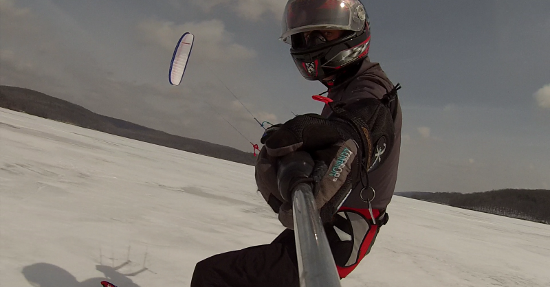 A person ice climbing on a glacier, bundled up in warm winter clothes with a bright red jacket, showcasing a unique winter adventure.