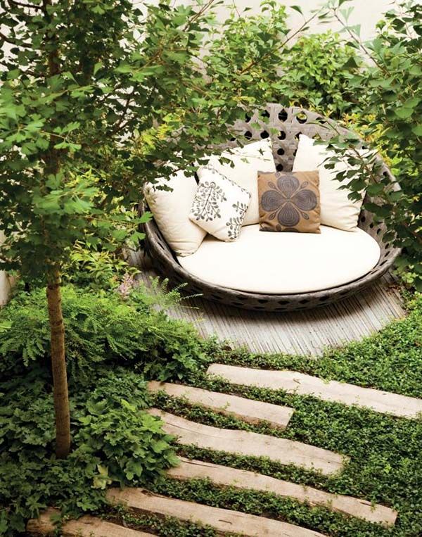 A close up of a woman reading on a back porch sofa.