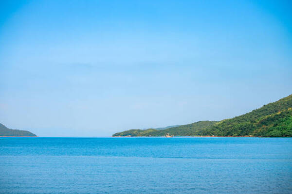 A breathtaking view of a tropical beach with crystal-clear water, white sand, and lush vegetation in the background, representing the beauty and pristine nature of eco-friendly beach destinations.