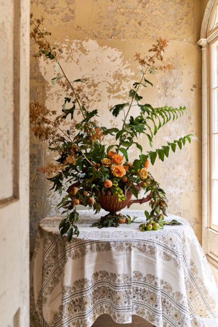 hands arranging flowers vase farmhouse table