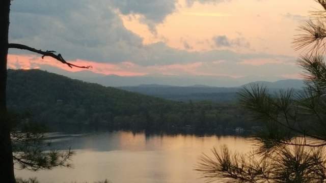 A dynamic photo of a climber on the Ivano Dibona via ferrata, showcasing the exposed position and the vast Dolomite peaks in the background. The image should be taken from a low angle to exaggerate the height and steepness of the climb.
