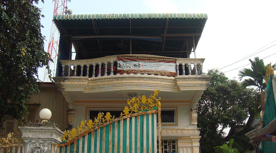 Participants preparing Amok Fish in a traditional wooden house surrounded by greenery during Lily's Secret Garden Cooking Class