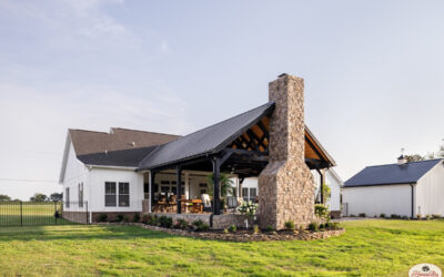 Exterior of an honest abe cabin with a large porch and stone pillars.