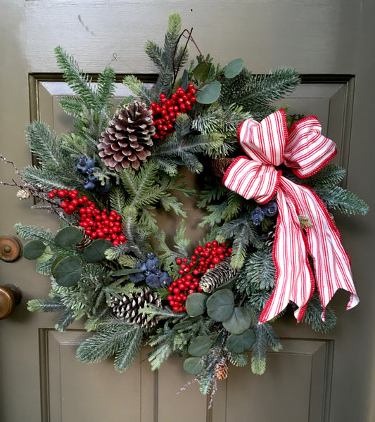 Assortment of freshly cut evergreen branches, showcasing the variety of textures and colors that can be used in the wreath.