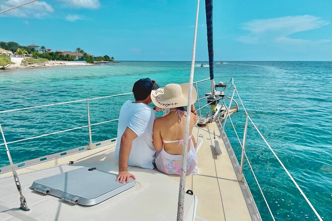 A couple enjoys a sunset cocktail on the deck of a private yacht, showcasing the luxurious and romantic ambiance of the British Virgin Islands.