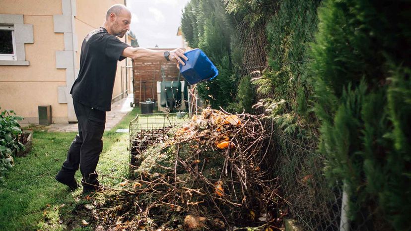 farmer aerating compost pile pitchfork
