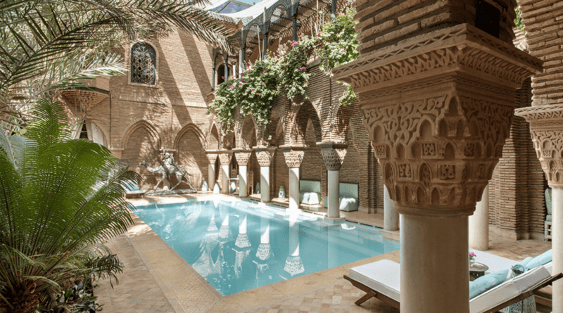 A photo of the rooftop terrace of Riad Yasmine, with views of the Atlas Mountains in the distance.