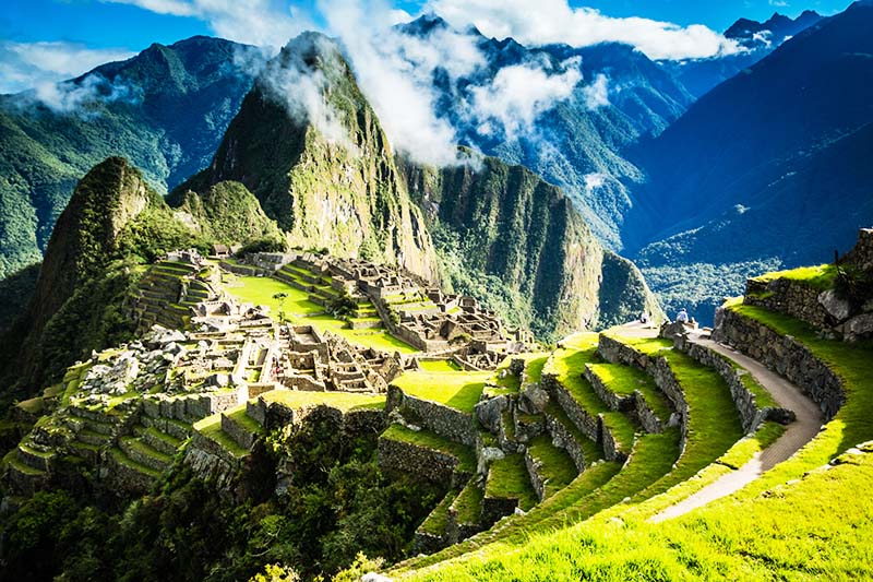 A panoramic view of Machu Picchu, nestled high in the Andes Mountains, shrouded in mist. The image captures the historical significance and the breathtaking landscape that makes the hike to Machu Picchu an unforgettable adventure.