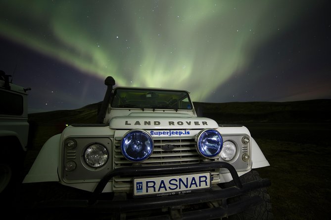 A family inside a Super Jeep laughing and pointing at the Northern Lights