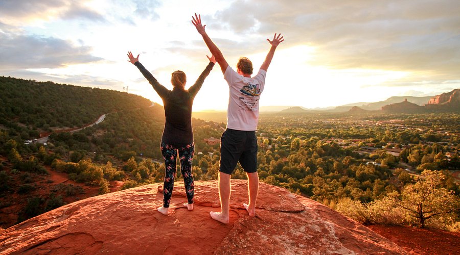 A woman meditating outdoors with Sedona's red rocks in the background, illustrating a meditation retreat experience.