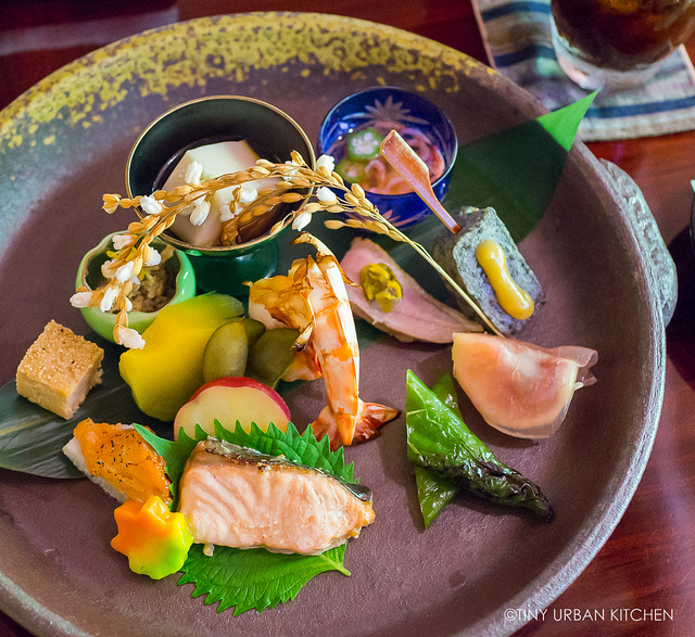 Kinkaku-ji Golden Pavilion reflected in the pond during cherry blossom season.