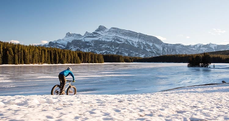 A panoramic shot of the Banff mountain range at sunrise, showcasing the alpenglow on the peaks, taken with a DSLR camera at f/8 for maximum sharpness and dynamic range