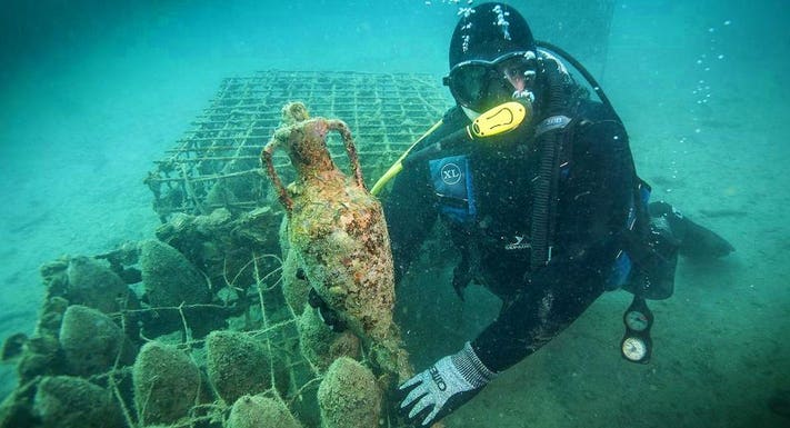 Underwater photography showcasing the amphorae covered in marine growth in Croatia's Underwater Wine Cellar.