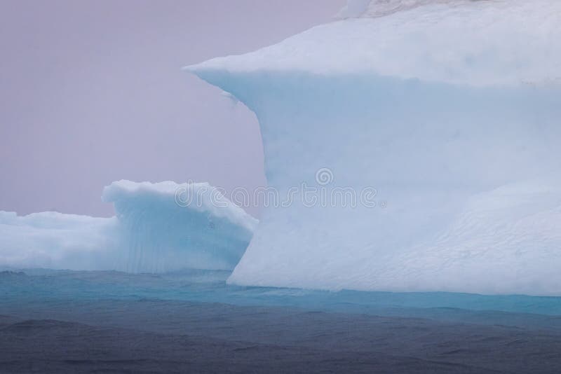 A climber in a wetsuit scaling a towering iceberg, with the vast Arctic Ocean stretching out in the background. Capture the moment of peak exhilaration just before the climber makes a controlled dismount into the icy water.