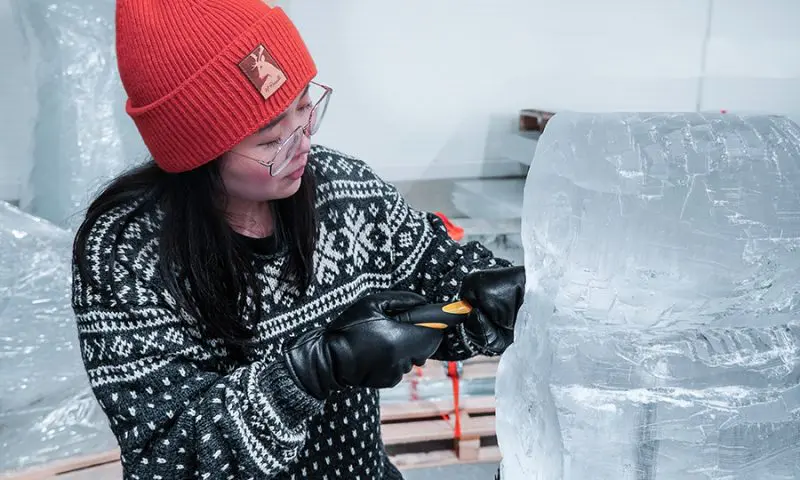 A Sami herder leading a reindeer sleigh