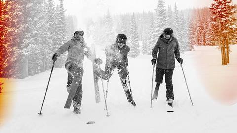 A ski ballet performer leaps against a blurred backdrop of the Rocky Mountains at golden hour, showcasing incredible form and athleticism.